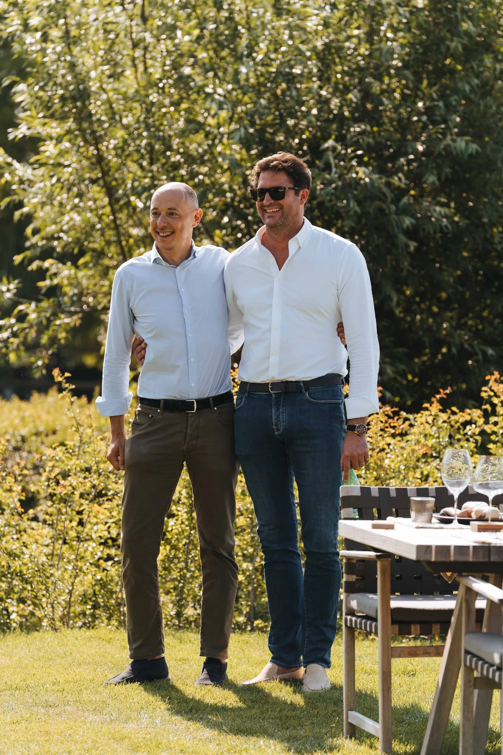 Arnaud Vandenbogaerde en Olivier Monteyne naast een gedekte tafel in de tuin
